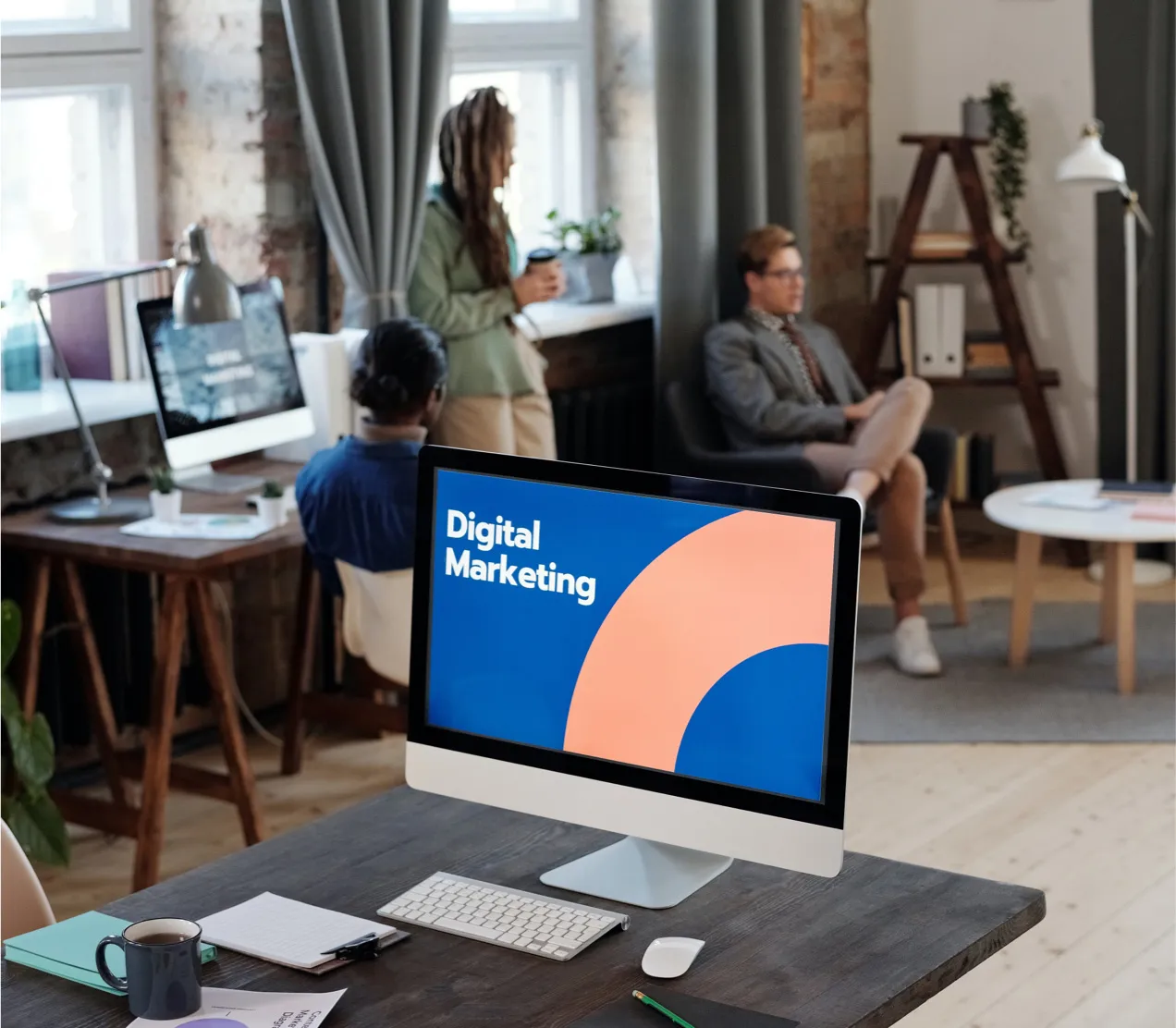مكتب مفتوح وعلى أحد المكاتب شاشة مكتوب عليها Digital Marketing
